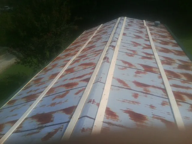 Rusted metal roof panels with new wood purlins before replacement — Storm Damage Roof Repair in Edmonton by Roofing Brothers